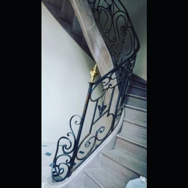 Rampe à volutes et pomme dorée, escalier de pierre